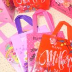 A set of 16 rose-colored HADDIY Mother's Day gift tote bags with floral patterns and handles, displayed together.