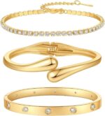 Four gold-plated bracelets, including a floral clover, tennis, chunky twist cuff, and classic bangle, stacked on a wrist.