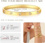 Four gold-plated bracelets, including a floral clover, tennis, chunky twist cuff, and classic bangle, stacked on a wrist.
