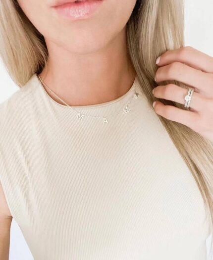 Close-up of a 14K gold plated 'Mama' pendant necklace on a delicate cable chain, with a glossy finish.