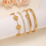 Four Zesnoy 18K gold-plated stackable clover bangle bracelets on a white background, showcasing their shine.